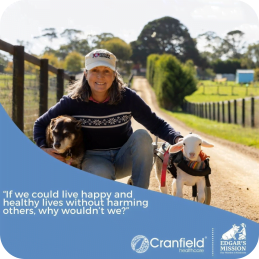 Woman smiling with a dog and a lamb on a farm path